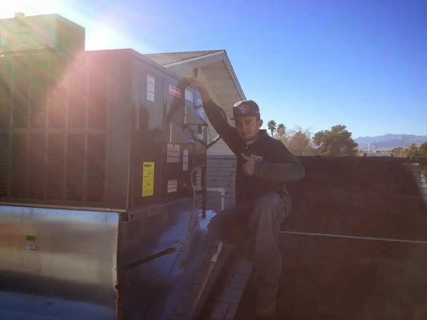 HVAC technician performing AC Tune-Up on a rooftop unit in Cambria